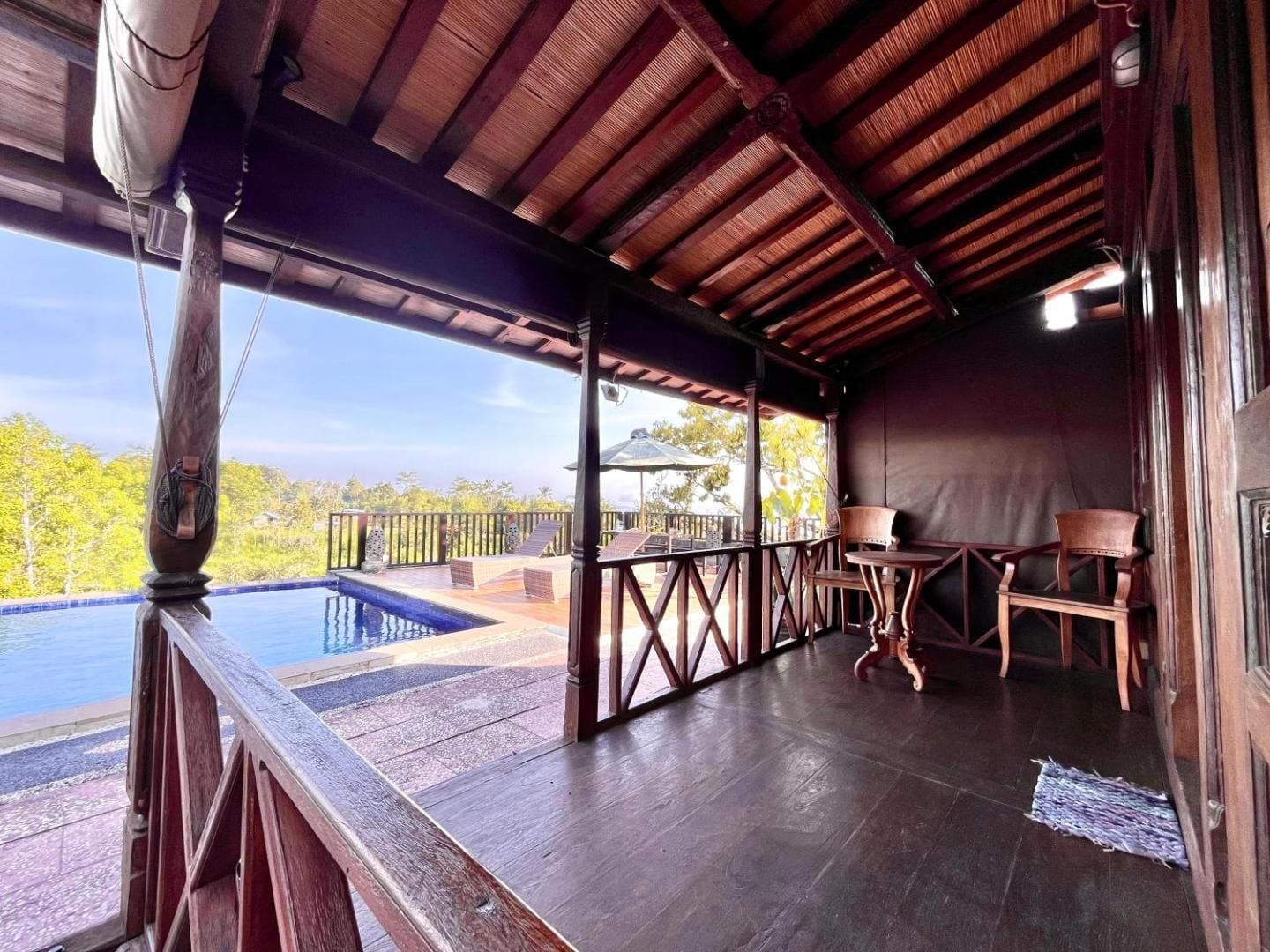 A bungalow veranda at Puri Karang, pool and valley beyond